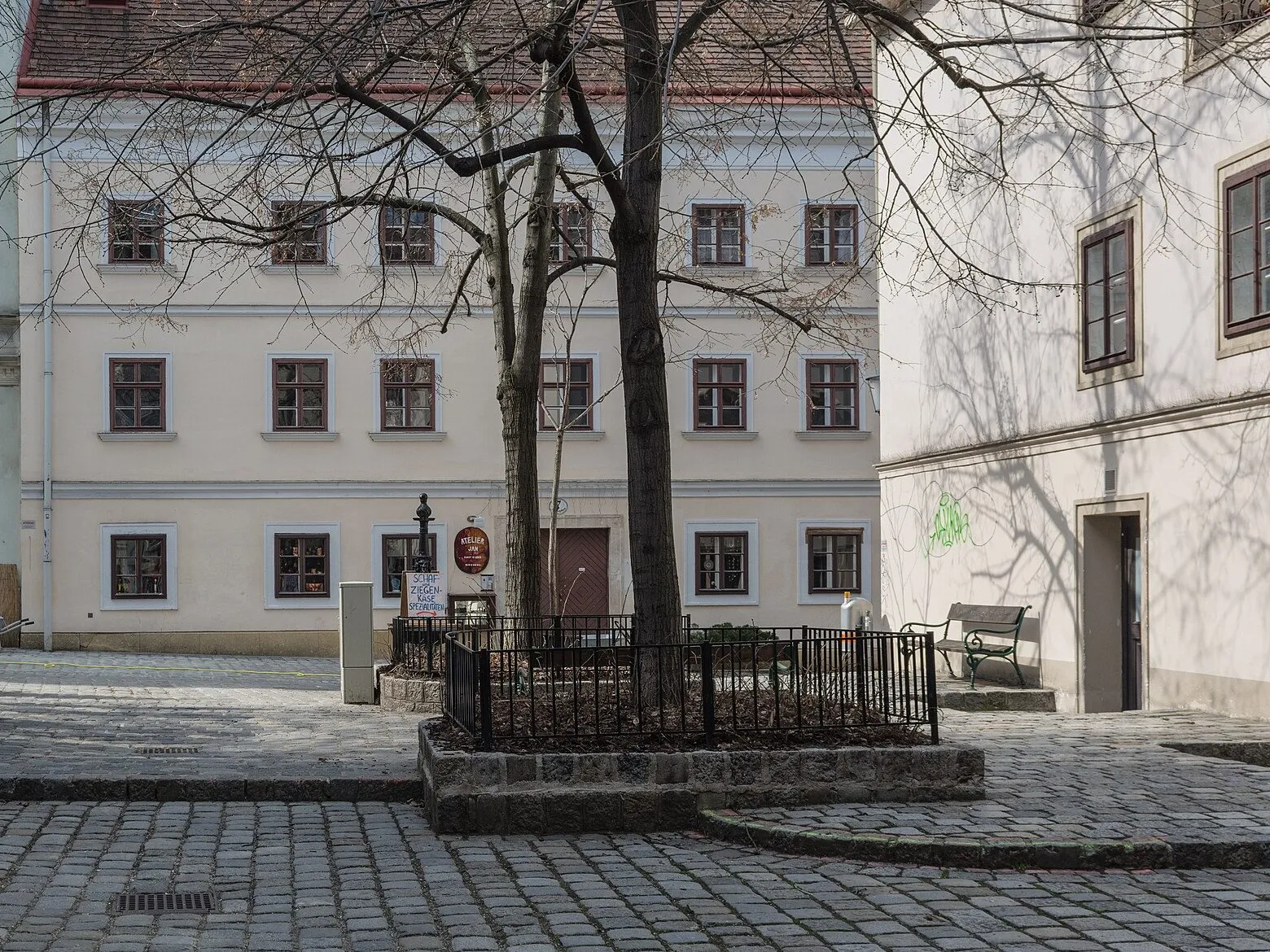 Ein ruhiger Platz mit Kopfsteinpflaster und Bäumen im Spittelberg-Viertel