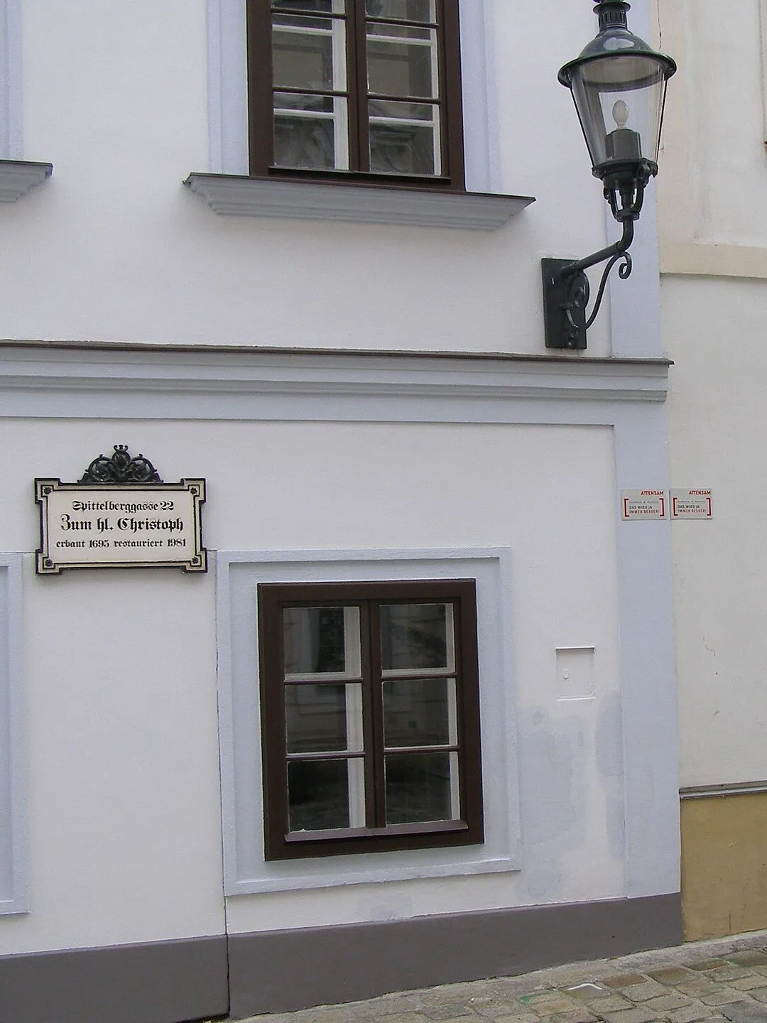 Weiße Biedermeier-Fassade mit Laterne und altem Hausschild in der Spittelberggasse